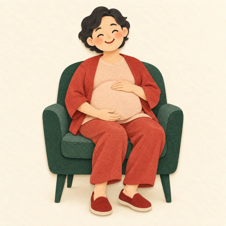 A smiling woman with a round belly sitting on a chair