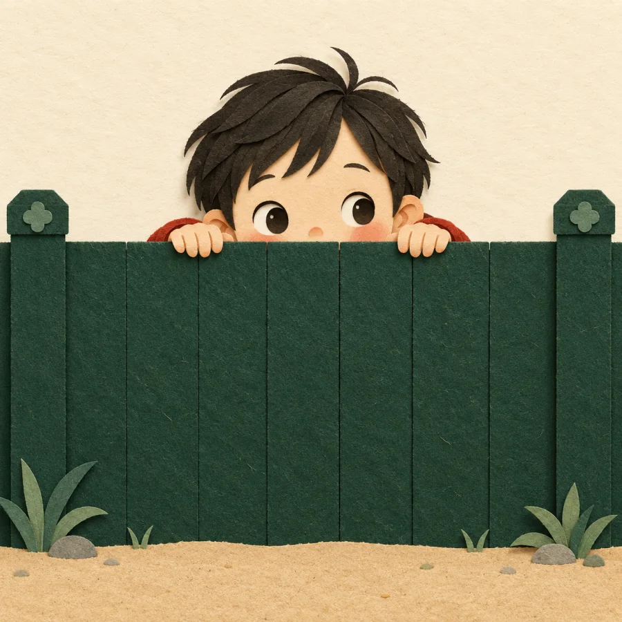 A child clings to a green fence and peeks over it