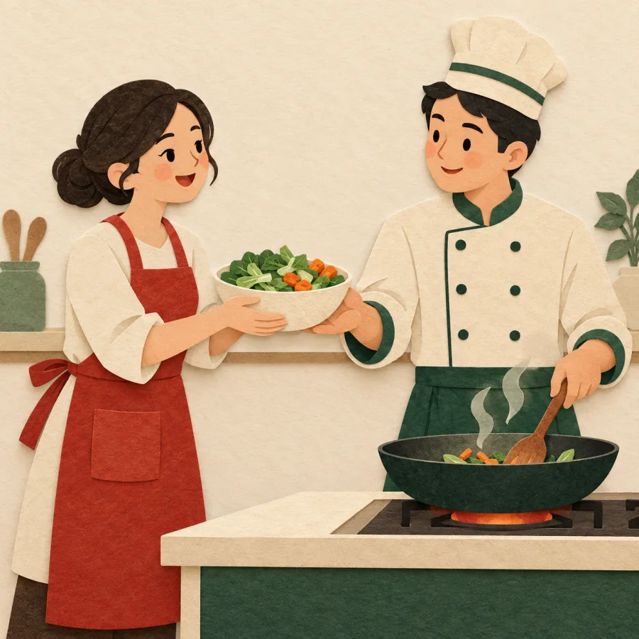 A person in an apron hands a bowl of vegetables to a cook
