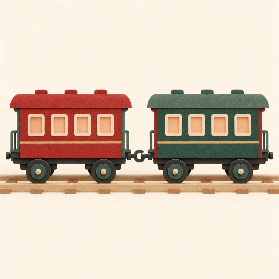 Two toy train carriages joined by a hook on a track.