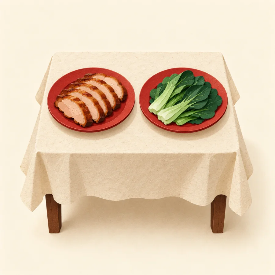 A table with a plate of meat and a plate of green vegetables