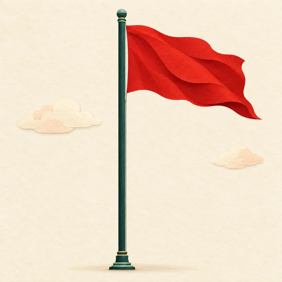 A red flag streams in the wind on a tall pole
